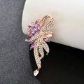 Rose gold flower brooch with purple marquise gems and crystals on a white pedestal - Rose Gold Crystal Flower