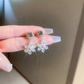 Macro view of purple zircon flower earrings with sparkling transparent crystal petals - Purple Round Zirconia Flower Style / Gold