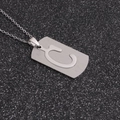 Gros plan d'un pendentif rectangulaire en acier argenté avec lettre C évidée sur fond noir - Lettre C