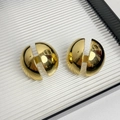 Vue macro de boucles d'oreilles demi-sphériques dorées avec finition métallique polie - Type J Boucles d'Oreilles Hémisphère Coupées Dorées
