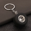 Macro view of detailed car tire keychain with polished silver metal wheel hub and rubber - White Gold