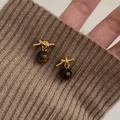 Boucles d'oreilles nœud doré vintage avec œil de tigre brun sur un pull en maille - Nœud Doré Oeil de Tigre