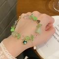 Close-up of a sweet green and clear beaded planet bracelet worn on a woman wrist - Green