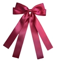 Detail of large magenta satin bow hair clip with flowing ribbons on white background - Burgundy