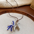 Detail of silver pony necklace with blue and white beaded tail on a rustic wooden tray - 27# Necklace Silver Blue-White Beaded Pony Tail