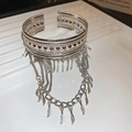 Détail d'un bracelet ouvert argenté vintage avec motifs géométriques et glands feuilles - Bracelet de Bras à Franges de Plumes Creuses / Argenté