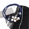 Gros plan sur les élastiques à cheveux bleus triple avec perles blanches et billes dorées - Bleu marine