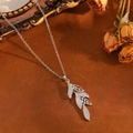 Détail macro du pendentif feuille argentée avec diamants sur un fond artistique vintage - Style de Feuille à Gland Argenté