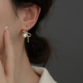 Elegant gold butterfly bow earrings with white pearl detail on female model - EH0576/Gold Bow Pearl Earring
