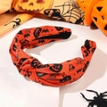 Macro detail of the knotted orange headband with black Halloween pumpkin and bat prints - Orange Pumpkin Spider Web