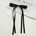 Detail shot of a black satin bow hair clip with long ribbons on a white background - Black