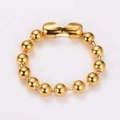 Primer plano de un anillo de cuentas de acero inoxidable chapado en oro 18k y pieza curva - Pulsera / Dorado