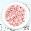 Macro detail of pink fish-shaped ceramic beads for DIY jewelry and handmade bracelets - Pink