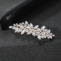 Vue détaillée d'une pince à cheveux motif feuille sertie de cristaux sur cuir noir - Style Zircone / Or