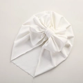 Detailed view of white baby turban featuring textured fabric and a large bow decoration - 21*17 cm / White