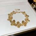 Vue détaillée d'un bracelet fleuri doré avec fermoir mousqueton dans un coffret blanc - Bracelet / Doré