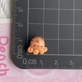 Macro shot of an orange octopus resin charm measuring 1.5cm on a black scale mat - Caramel Roasted Octopus