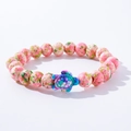 Close-up of pink spotted stone beads with a blue and purple turtle charm bracelet - Pink Green Yellow Spotted Colorful Turtle Wood Bracelet