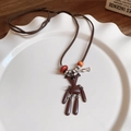 Dettaglio della collana vintage con ciondolo a orso e perline su un cordoncino di cuoio - Collana in Corda con Orso Marrone Vintage