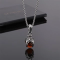Gros plan d'un pendentif griffe de dragon punk avec perle ambre et chaîne élégante - Griffe Perle Brun Rouge