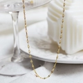 Detailed close-up of golden petal-link stainless steel necklace chain on a white plate - Gold Petal Chain
