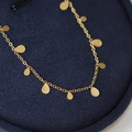 Damen-Halskette mit goldenen Tropfenanhängern auf blauem Samt-Präsentationshintergrund - Halskette mit Wassertropfen-Anhänger / Gold