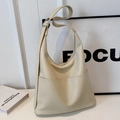 Chic beige lychee textured bucket bag with large front pocket and wide strap - Off-white