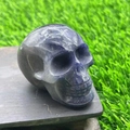 Deep purple-grey semi-precious natural stone skull sculpture on wooden base - Blue Aventurine