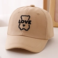 Detail of embroidered LOVE bear logo on a khaki cotton twill baseball cap for kids - 52cm (2-5 Years) / Khaki