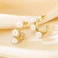 Detail of C-shaped golden stainless steel earrings featuring white pearls and hollow texture - 19*7mm / Gold