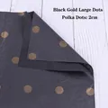 Detail of black floral wrapping paper with 2cm gold polka dots on white wood background - Black Gold Big Dots