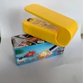 Mini plastic bag heat sealer in bright yellow color with its colorful product packaging - Chinese Packaging / Yellow