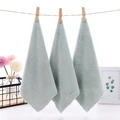Three-piece set of light green coral fleece square towels with wavy edges hanging on a rope - Green