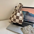 Brown and white checkered knit tote bag with face pattern on a laptop surface - Khaki Smile Face