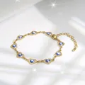 Macro detail of gold heart link bracelet featuring blue evil eye beads and lobster clasp - Blue Eye