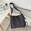 Detail der blauen Denim-Hobo-Tasche auf einem Stuhl mit breitem Gurt und Silberschnalle - Dunkelblau