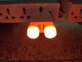 Veilleuse LED USB à double tête avec lueur orange chaude branchée sur une multiprise - Rouge