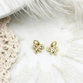 Mini gold bow pendants set with sparkling zircon stones on a soft lace background - Bow