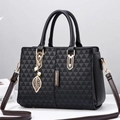 Black tote bag with geometric embossed texture, golden hardware and leaf pendant charm - Black