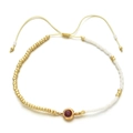 Detail of adjustable handmade beaded bracelet with golden beads and red zircon stone - Burgundy
