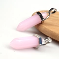 Pink quartz hexagonal double point pendant with silver metal bail on wooden surface - Pink Jade