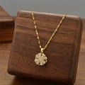 Golden clover pendant necklace with zircon micro-inlay on elegant wooden display - Rotating Necklace / Gold