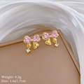Detail van roze kristallen strik oorbellen met goudlaag en zirkonia op zijde - Roze Goud / Roze Strik Oorknopjes (A118)