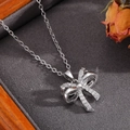 Dettaglio macro del ciondolo a fiocco argento con pavé di zirconi e perla - Collana con Fiocco a Doppio Strato Traforato Argento
