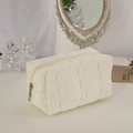 Detail of cream plush makeup bag with diamond quilt pattern and silver glitter accents - Off White
