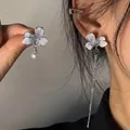 Dettaglio di orecchini a fiori blu asimmetrici con perla e nappa in metallo elegante - Argento-Blu (6# Perno in Argento)