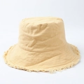 Macro detail of beige bucket hat featuring vintage frayed edges and cotton canvas texture - Beige