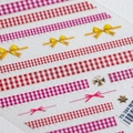 Macro detail of 3D embossed red plaid nail stickers with gold bow motifs TS-384 - TS-384 Rose Love