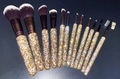 Flat lay detail of 13 sparkling makeup brushes with gold rhinestones and soft brown bristles - Mixed Gold
