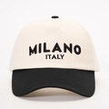 Detailopname van MILANO ITALY-letters op een tweekleurige katoenen honkbalpet - Crème/Zwart